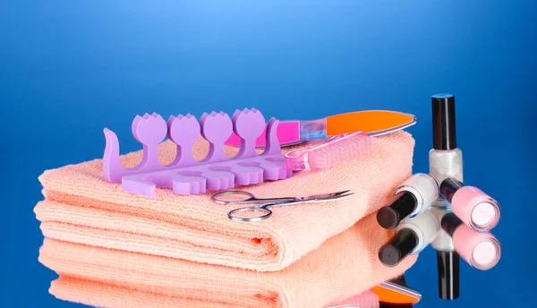 Pedikyr på rosa handduk på blå bakgrund — Stockfoto
