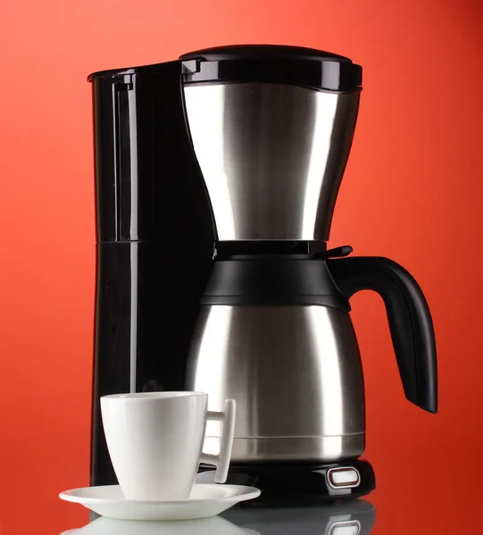 Kaffeemaschine mit weißer Tasse auf rotem Hintergrund — Stockfoto