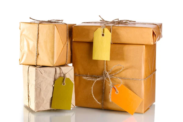 Many parcels wrapped in brown paper tied with twine and with blank labels i — Stock Photo, Image