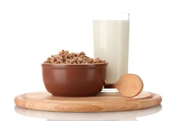 一杯牛奶在一个木制板上孤立的棕色碗里的水煮的荞麦 — 图库照片