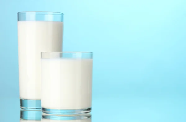 Twee glazen van melk op blauw — Stockfoto