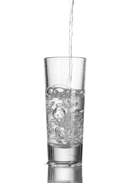 Vodka versata in un bicchiere isolato su bianco — Foto Stock