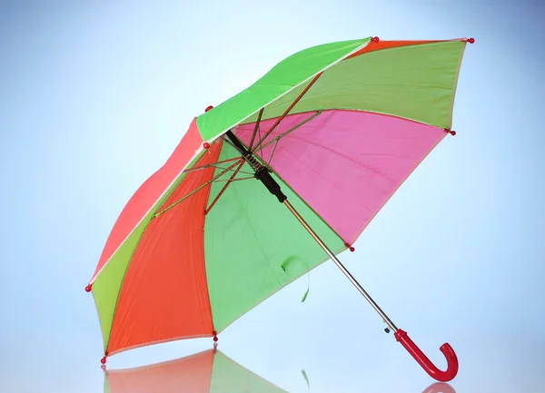 Mehrfarbiger Regenschirm auf blauem Hintergrund — Stockfoto