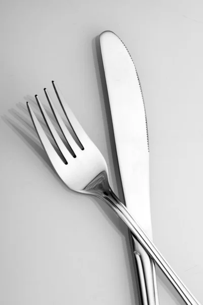 Tenedor y cuchillo de plata sobre fondo gris — Foto de Stock