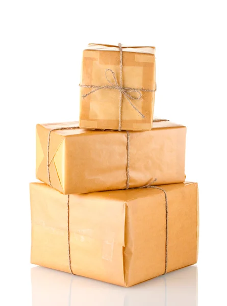Tres paquetes envueltos en papel marrón atados con torzal dispuestos en isol de pila — Foto de Stock
