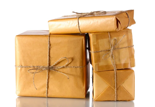 Molti pacchi avvolti in carta marrone legati con spago isolato su bianco — Foto Stock