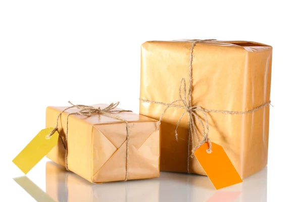 Two parcels wrapped in brown paper tied with twine and with blank labels is — Stock Photo, Image