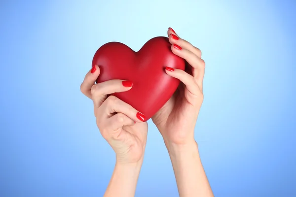 Rood hart in womans handen op blauwe achtergrond — Stockfoto