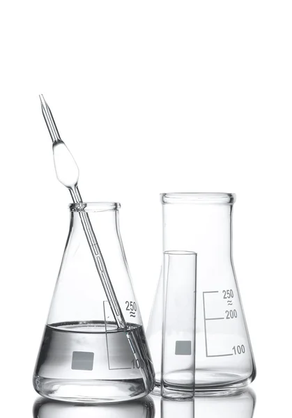Un frasco con agua y dos frascos vacíos con reflexión aislada sobre blanco —  Fotos de Stock