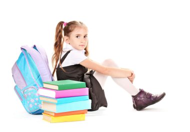 güzel küçük bir kız, kitap ve üzerinde beyaz izole bir sırt çantası