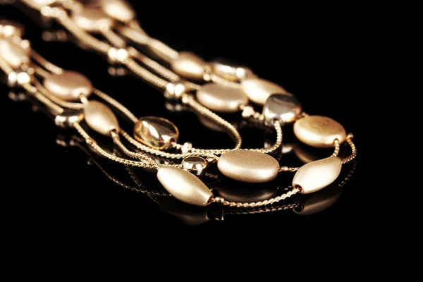 stock image Beautiful gold necklace on black background