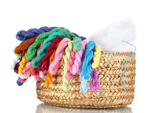 Яскраві нитки для рукоділля і тканини в плетеному кошику — стокове фото