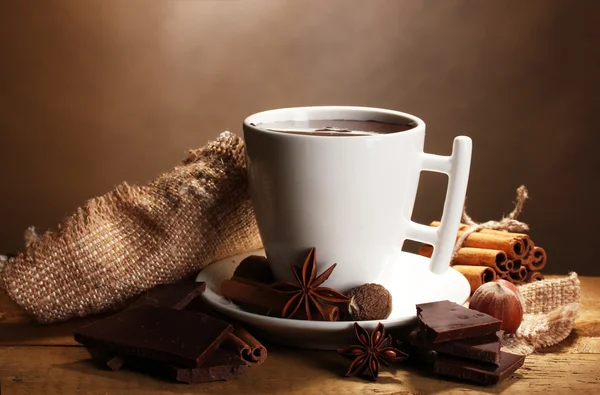 ホット チョコレート、シナモンスティック、ナッツ、木製テーブル o にチョコレートのカップ — ストック写真