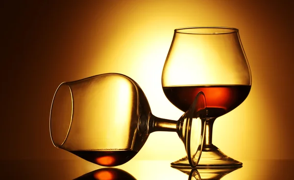 Två glas cognac på gul bakgrund — Stockfoto