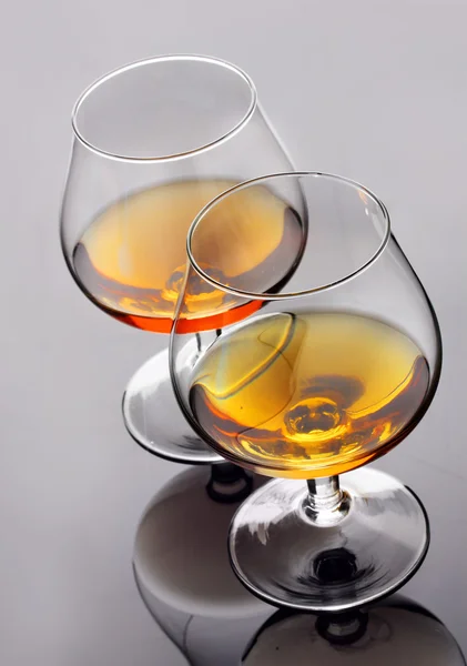 Zwei Gläser Cognac auf grauem Hintergrund — Stockfoto