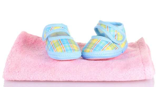 Botas de bebê azul na toalha rosa isolada no branco — Fotografia de Stock