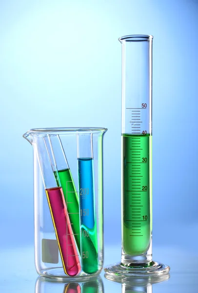 Laboratoriumglaswerk met kleur vloeistof en reflectie op blauwe CHTERGRO — Stockfoto
