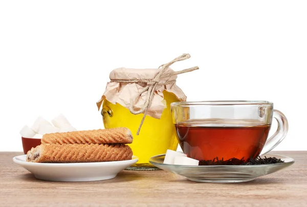 Heerlijk ontbijt van thee, koekjes en honney op grijze achtergrond — Stockfoto