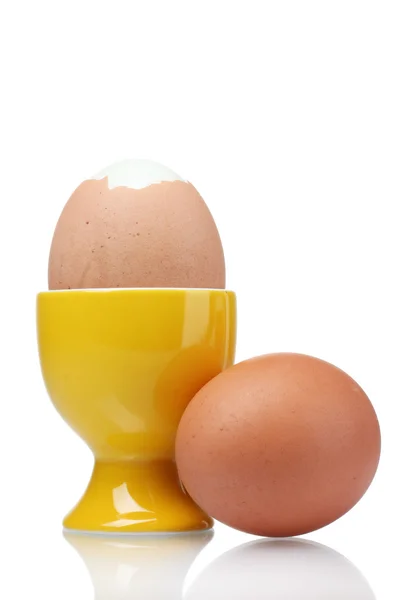 Gekookte eieren in gele stand geïsoleerd op wit — Stockfoto
