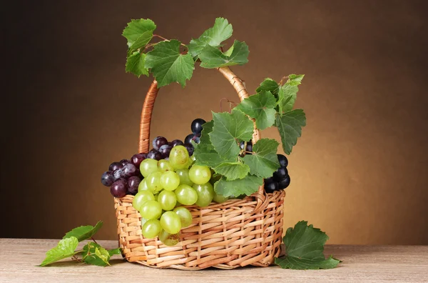 Uvas maduras em uma cesta no fundo amarelo — Fotografia de Stock