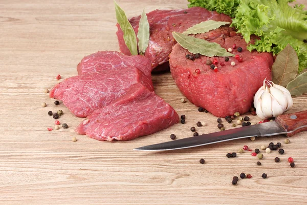 Rått kött och kryddor på trä bakgrund — Stockfoto