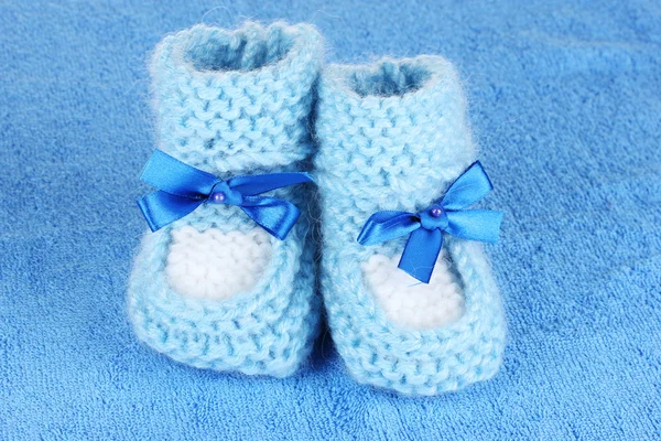 Blue baby booties on blue background — Stok fotoğraf