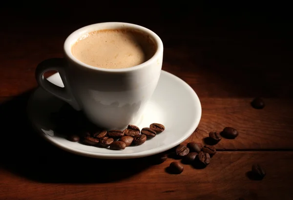 나무 테이블에 커피 원두와 커피 컵 — 스톡 사진