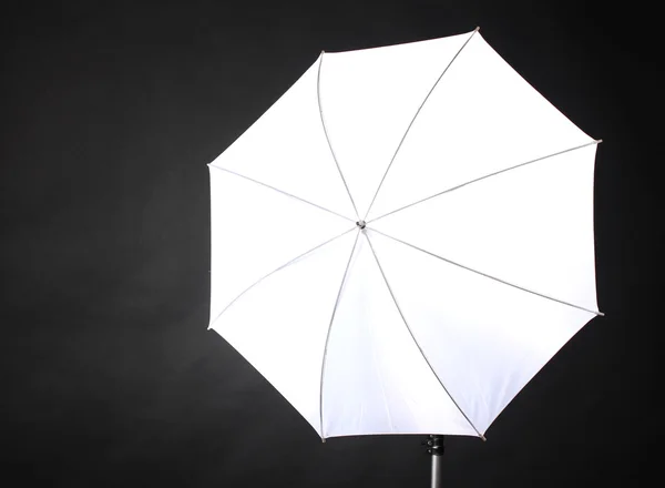 Студійний спалах з парасолькою на сірому фоні — стокове фото