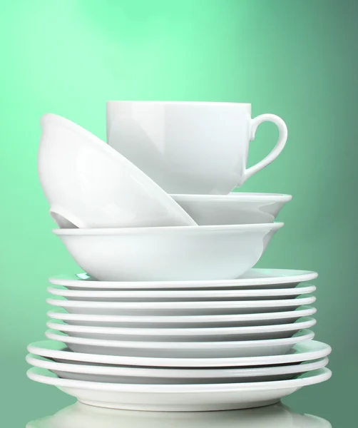 Καθαρά πιάτα και κύπελλο σε πράσινο φόντο — Φωτογραφία Αρχείου