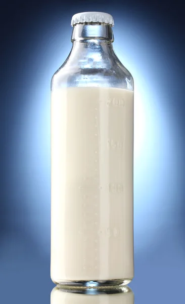 Bottiglia di latte su fondo blu — Foto Stock