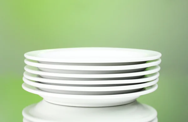 Чистые тарелки на зеленом фоне — стоковое фото