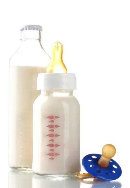Flaskor av mjölk och nappen isolerad på vit — Stockfoto