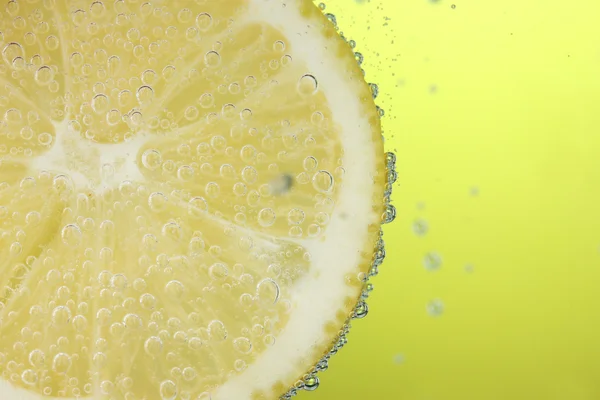 Zitronenscheibe im Wasser mit Blasen — Stockfoto
