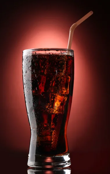 Glass of cola with ice on red background — Stock Photo, Image
