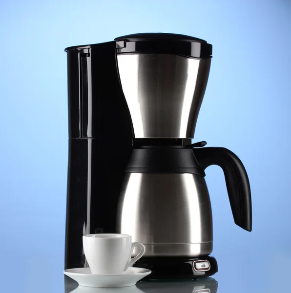 Mavi zemin üzerine beyaz fincan kahve makinesi — Stok fotoğraf