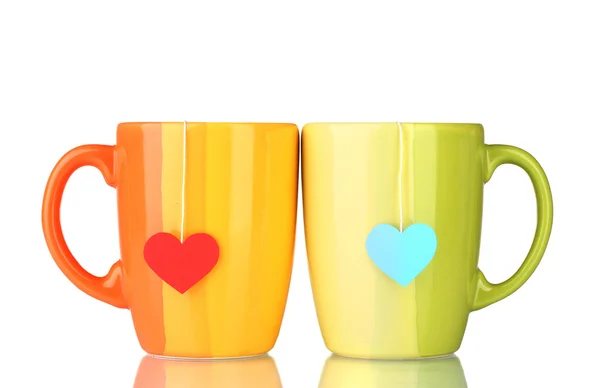Two cups and tea bags with red and blue heart-shaped label isolated on whit — Stock Photo, Image