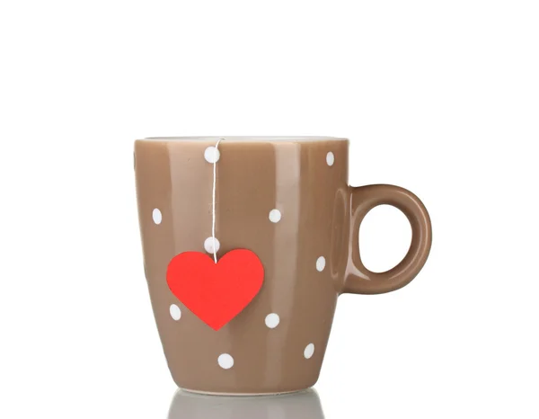 Xícara marrom e saco de chá com rótulo vermelho em forma de coração isolado no branco — Fotografia de Stock