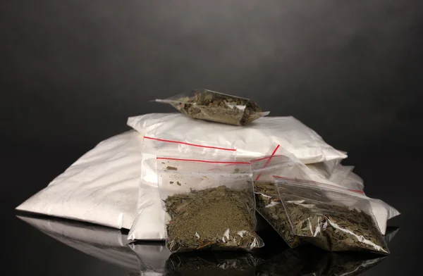 Κοκαΐνη και η μαριχουάνα σε συσκευασίες σε γκρι φόντο — Φωτογραφία Αρχείου