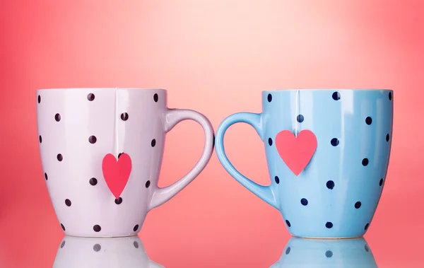 Deux tasses et sachets de thé avec étiquette rouge en forme de coeur sur fond rouge — Photo