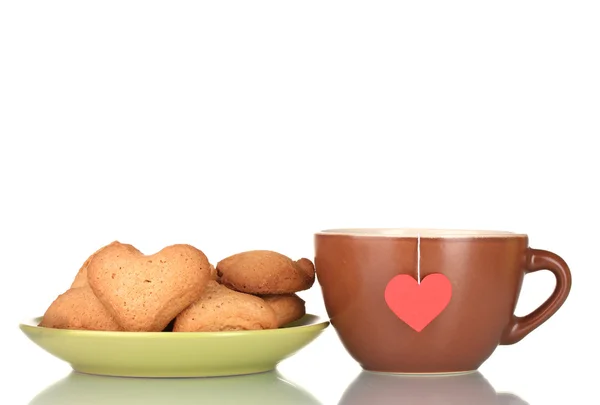 Zelený pohár s sáček čaje a srdce tvaru cookies na zelené desky izolována na — Stock fotografie