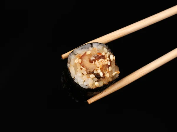 用筷子被隔绝在黑色控股辊 — 图库照片