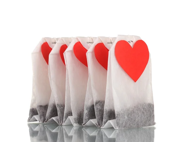 Tea bags with blank heart-shaped labels isolated on white — Stock Photo, Image