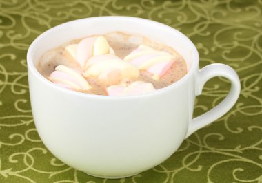 Yeşil masa örtüsü üzerinde marshmallow ile cappucino bardak