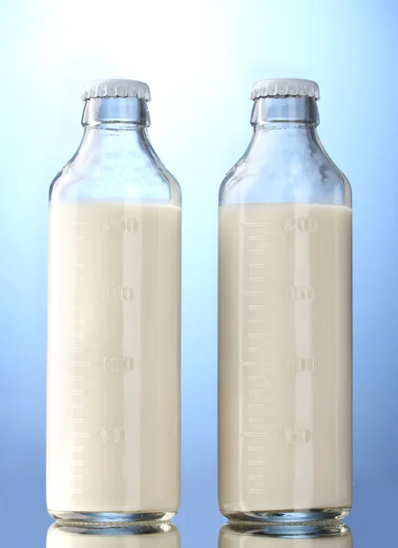 Mavi zemin üzerine süt şişesi — Stok fotoğraf