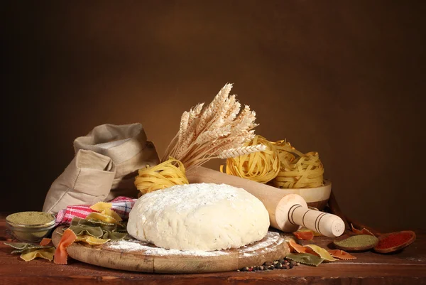 Ingredientes para massas caseiras na mesa de madeira no fundo marrom — Fotografia de Stock