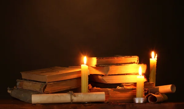 在黑暗中桩的旧书籍与蜡烛和滚动 — 图库照片