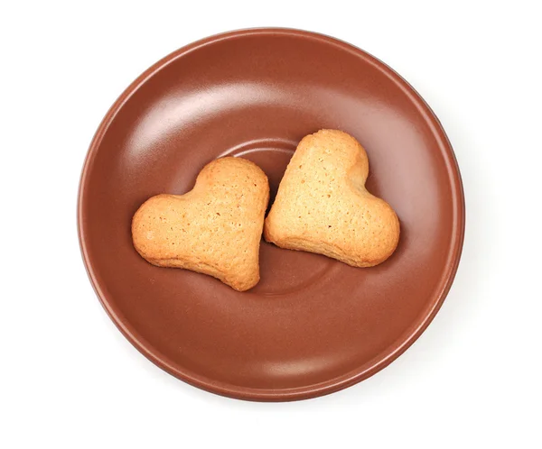 Dois biscoitos em forma de coração em pires castanhos isolados em branco — Fotografia de Stock