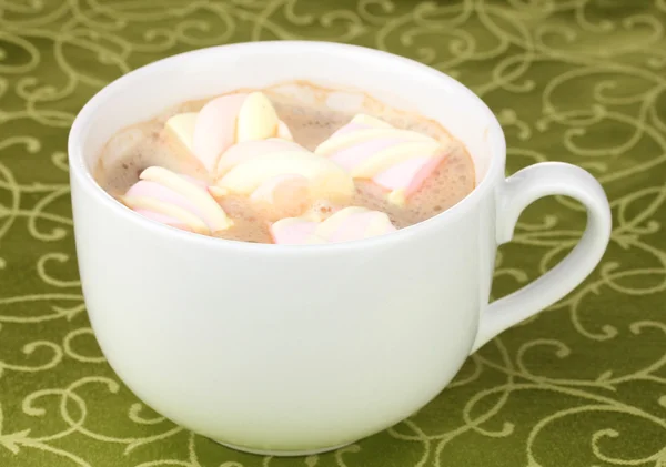 Xícara de cappucino com marshmallows na toalha de mesa verde — Fotografia de Stock