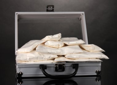 Cocaine in a suitcase on grey background clipart