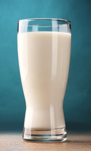 Glas melk op houten tafel op blauwe achtergrond — Stockfoto